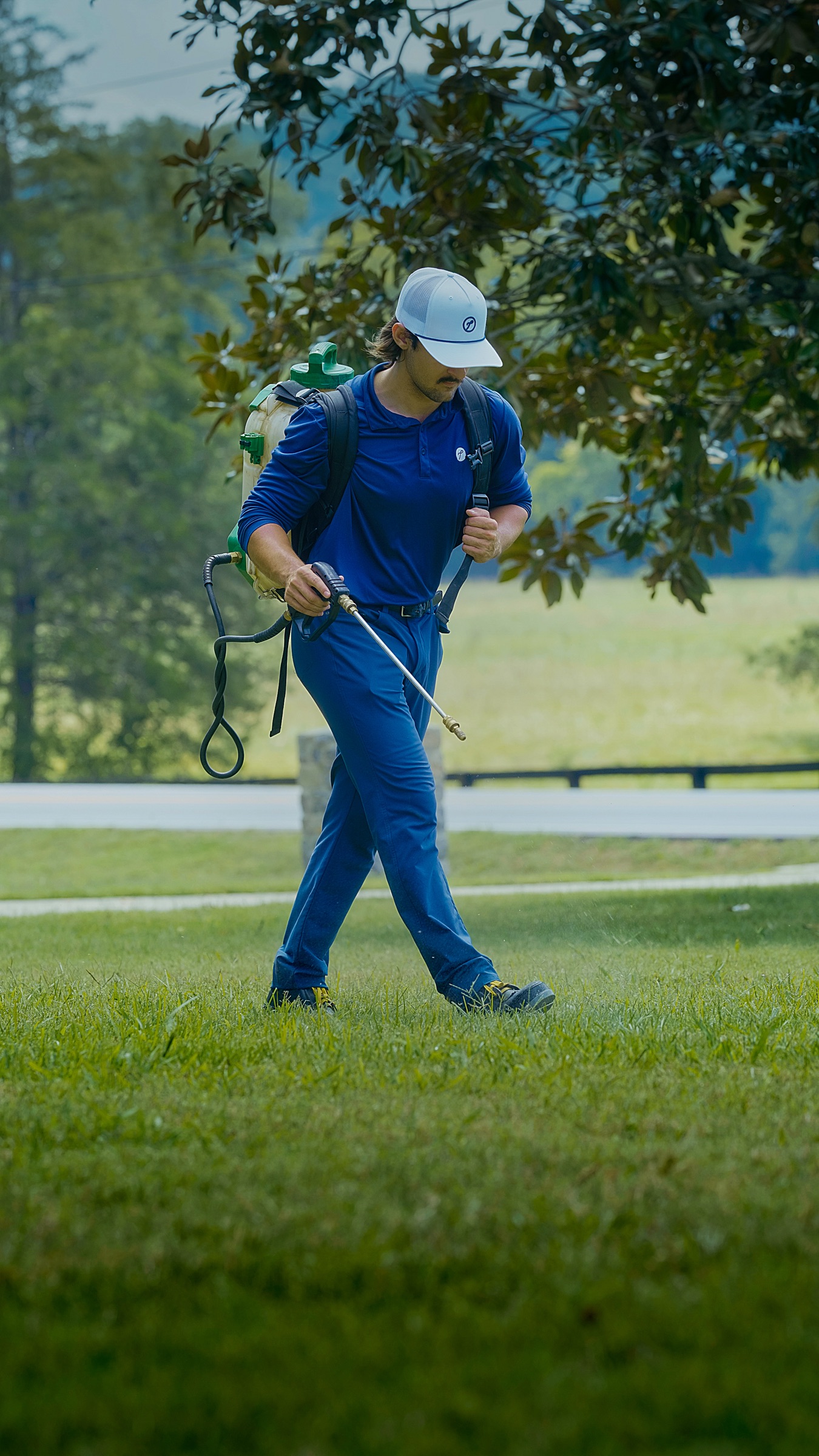 A technician treating a lawn with a backpack sprayer