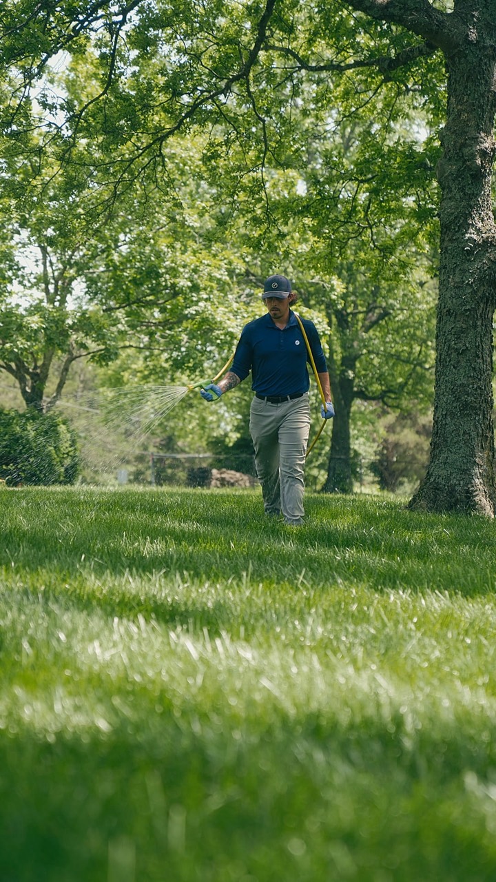 A Pure Turf technician treating a shaded lawn